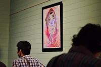 a group of people looking at a painting on a wall