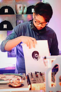 a dj is putting a t shirt on a table
